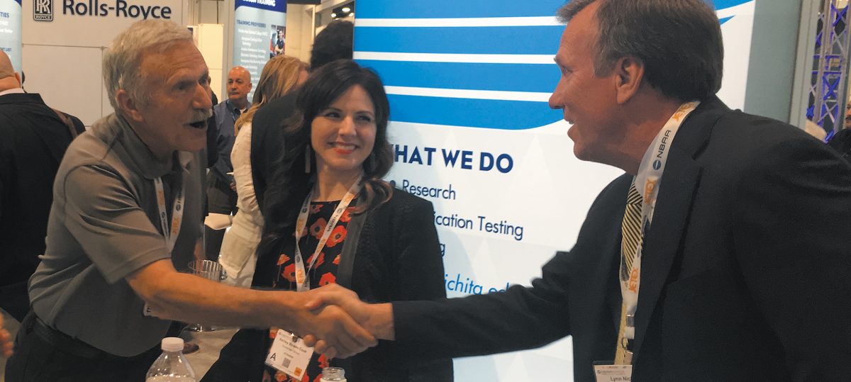 Aviation Photographer Paul Bowen shakes hands with Yingling Aviation CEO Lynn Nichols at NBAA 2017